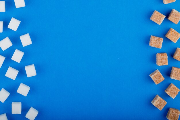 Odgórny widok białego i brown cukrowego sześcianu układał na błękitnym tle z kopii przestrzenią