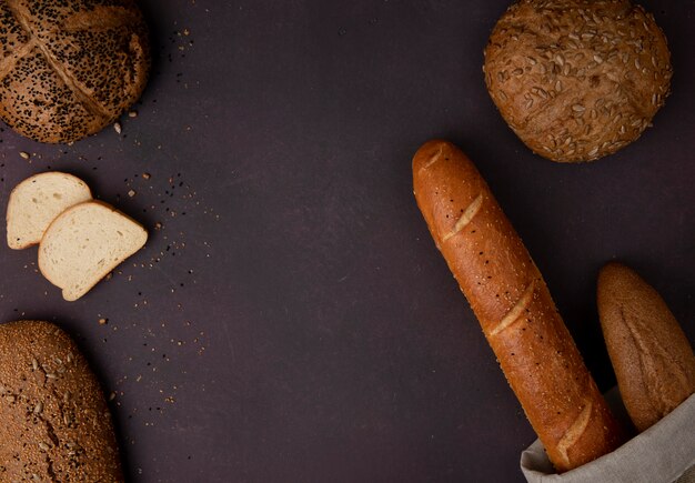 Odgórny widok chleby jako biały baguette cob na lewej i prawej stronie i kasztanowy tło z kopii przestrzenią