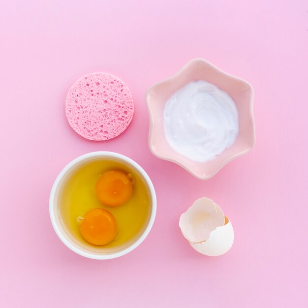 Odgórny widok ciało masło i jajka na różowym tle