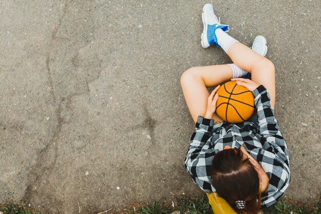 Odgórny widok dziewczyna z koszykówki obsiadaniem