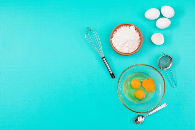 Odgórny widok jajka z mąki i kopii przestrzenią na błękitnym tle horyzontalnym