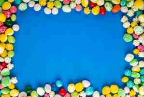 Bezpłatne zdjęcie odgórny widok kolorowi słodcy cukrowi cukierki na błękitnym drewnianym tle z kopii przestrzenią