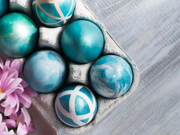 Odgórny widok malujący Easter jajka w kartonie z kwiatami i kopii przestrzenią