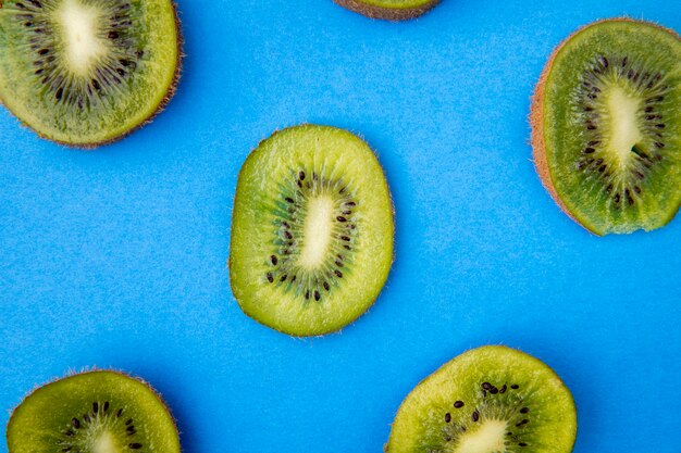 Odgórny widok plasterki odizolowywający na błękicie kiwi owoc