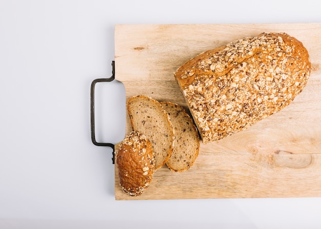 Odgórny widok pokrojony wholegrain chleb na ciapanie desce nad białym tłem