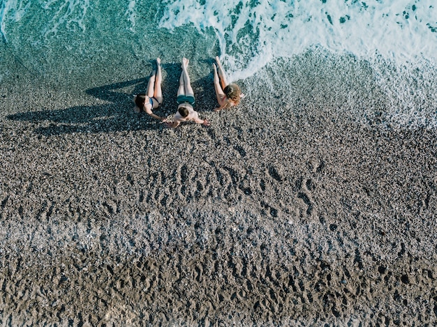 Bezpłatne zdjęcie odgórny widok przyjaciele relaksuje przy plażą