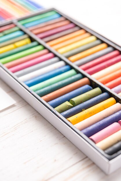 Odgórny widok różna kolorowa pastelowa farba i markiery w pudełkach na bielu stole