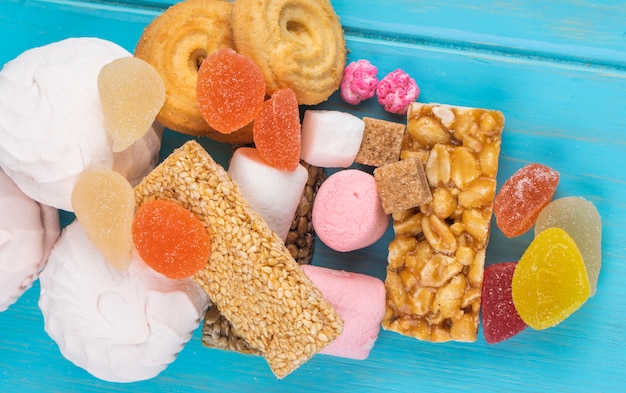 Odgórny widok różnorodni cukierki kozinaki marshmallow marmoladowi cukierki i ciastka na błękicie