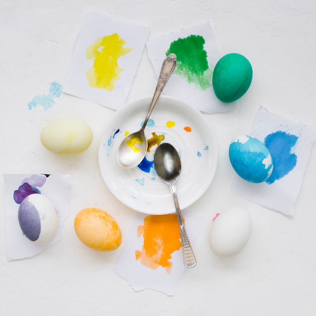 Odgórny widok talerz z łyżkami i kolorowymi jajkami dla Easter