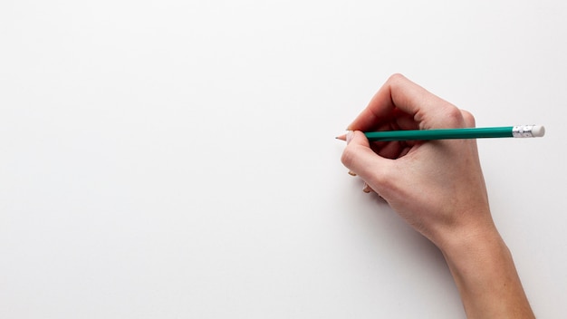 Bezpłatne zdjęcie odgórny widok trzyma ołówek z kopii przestrzenią ręka