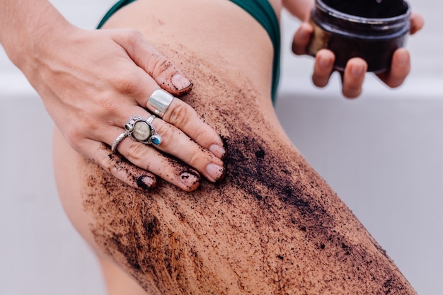 Bezpłatne zdjęcie odkryty strzał kobiety z peelingiem do ciała kawy.