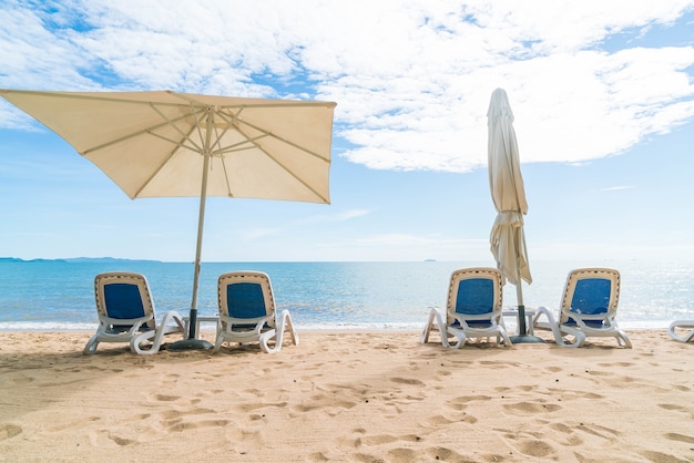 Odkryty z parasolem i krzesło na pięknej tropikalnej plaży i morza