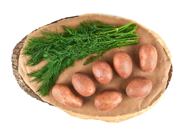 Odmiany zieleni z ziemniakami na drewnianym talerzu.