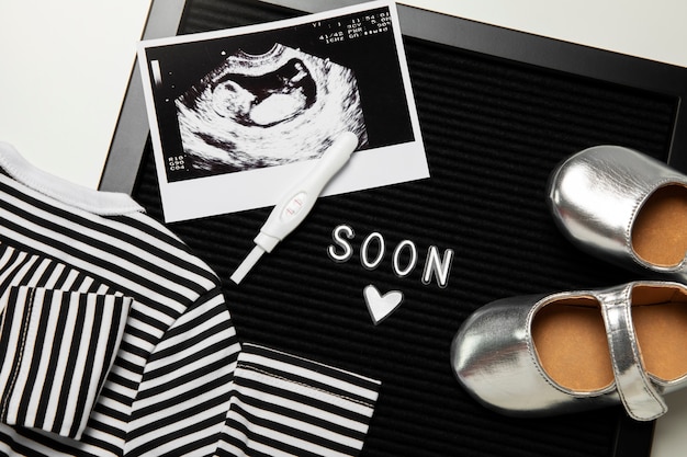 Bezpłatne zdjęcie ogłoszenie ciąży leżącej płasko z artykułami dla niemowląt