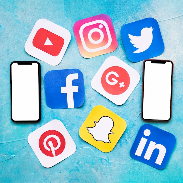 Bezpłatne zdjęcie ogólnospołeczne medialne ikony z dwa pustymi telefon komórkowy na błękit malującej ścianie