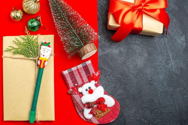 Ogólny widok świątecznego nastroju z akcesoriami do dekoracji choinki prezentowa skarpeta na czerwonym i czarnym tle