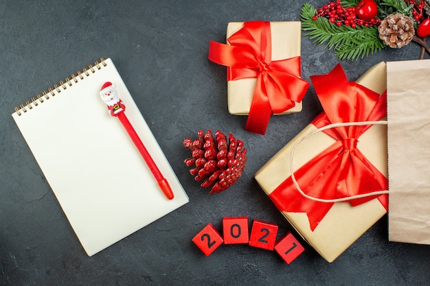 Ogólny widok świątecznego nastroju z szyszkami i gałęziami jodły prezent obok notebooka na ciemnym stole