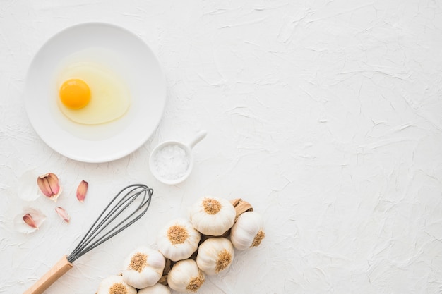 Bezpłatne zdjęcie ogólny widok żółtka jaja; czosnek i sól na białym tle z teksturą
