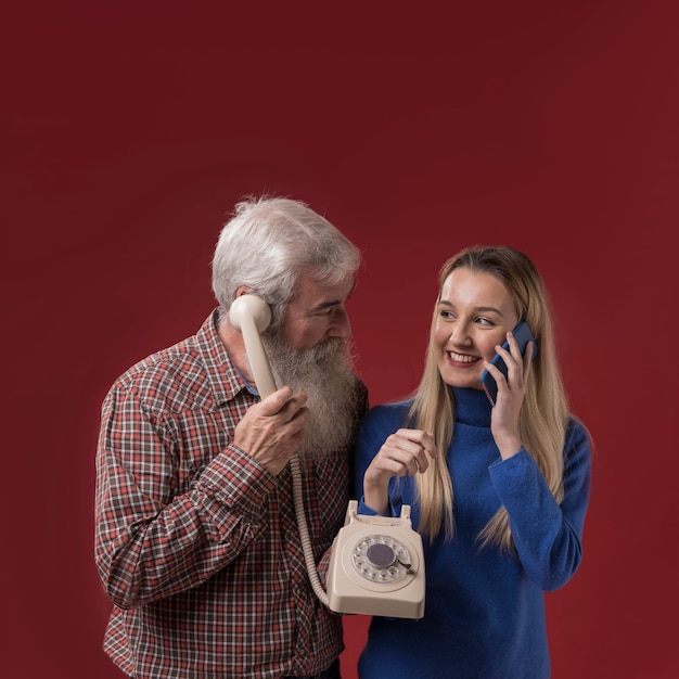 Bezpłatne zdjęcie ojciec i córka trzyma starego telefon