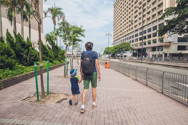 Ojciec i syn spacerują po hongkongu. podróżowanie z pojęciem dzieci.