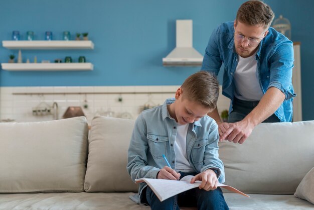 Ojciec jest pomocny w odrabianiu lekcji przez syna