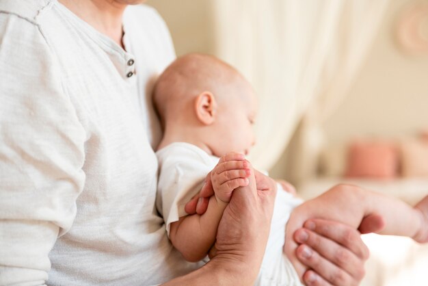 Ojciec trzymając się za ręce z noworodka