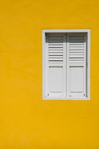 okno na żółtej ścianie