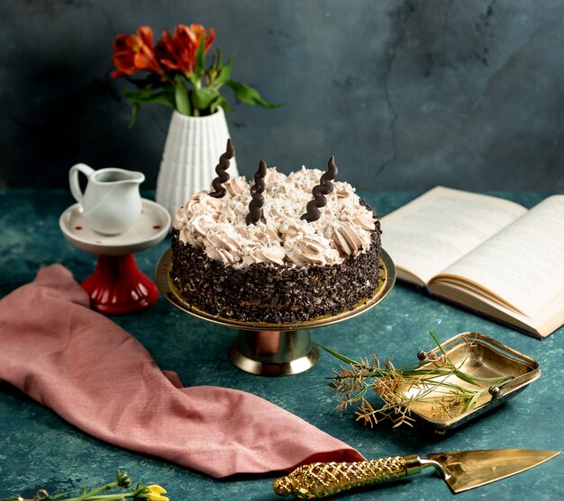 Bezpłatne zdjęcie okrągłe ciasto ozdobione czekoladowymi kratkami i śmietaną z kawą