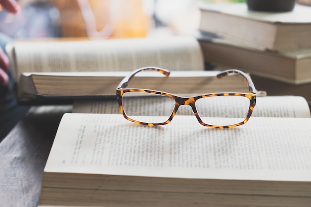 Bezpłatne zdjęcie okulary na otwarcie książki w bibliotece lub kawiarni.