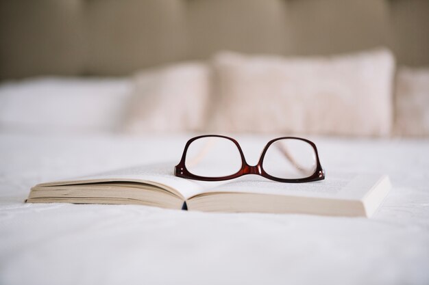 Okulary na otwartej książki na łóżku