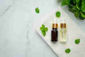 Bezpłatne zdjęcie olejek eteryczny z mięty pieprzowej w butelce ze świeżą zieloną miętą