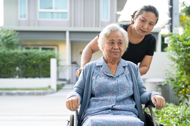 Opiekun pomocy i opieki azjatycka starsza lub starsza starsza kobieta pacjentka siedząca na wózku inwalidzkim na oddziale szpitala pielęgniarskiego, zdrowa, silna koncepcja medyczna