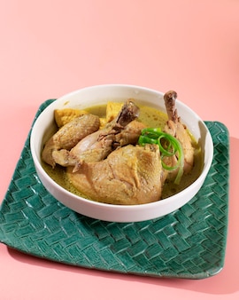 Opor ayam (indonezyjskie żółte curry z kurczaka) w menu lebaran, zwykle podawane z ketupat, sambal goreng ati kentang i semur telur. popularne danie dla id al fitr