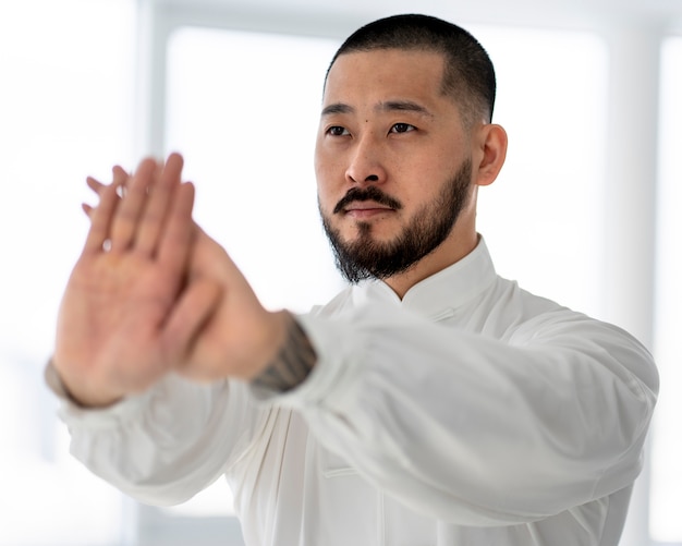 Bezpłatne zdjęcie osoba ćwicząca tai chi w pomieszczeniu