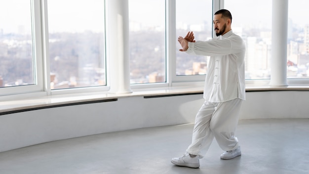 Bezpłatne zdjęcie osoba ćwicząca tai chi w pomieszczeniu