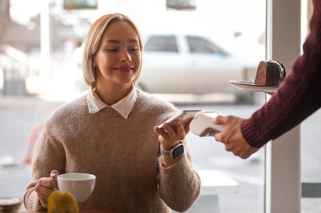 Bezpłatne zdjęcie osoba korzystająca z technologii nfc do płacenia w restauracji