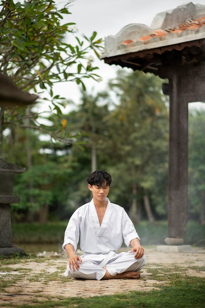 Osoba medytująca przed treningiem taekwondo