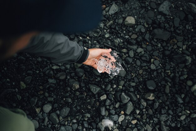Osoba posiada kawałek lodu lodowcowego w Islandii