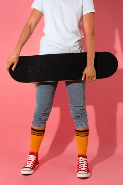 Osoba pozująca ze skateboardem