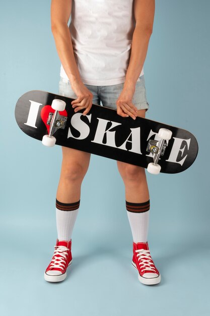 Osoba pozująca ze skateboardem