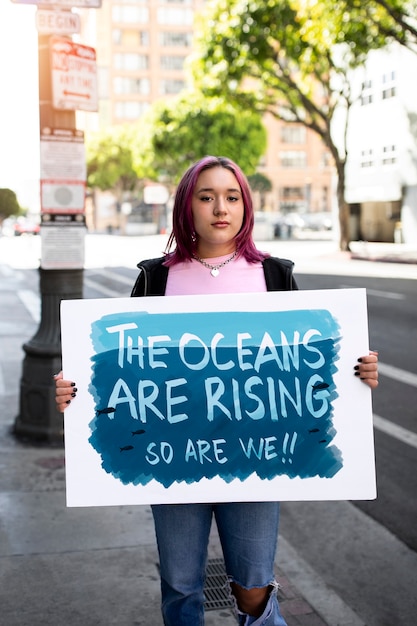 Osoba protestująca z tabliczką na światowy dzień ochrony środowiska na zewnątrz