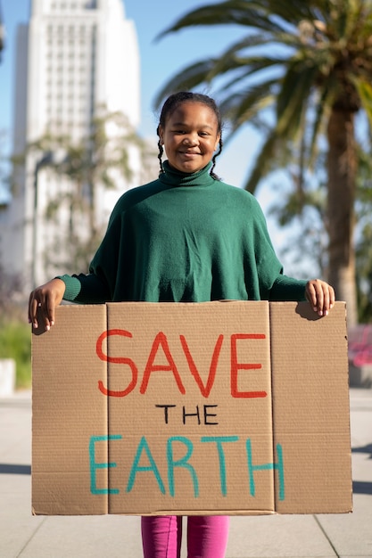 Osoba protestująca z tabliczką na światowy dzień ochrony środowiska na zewnątrz