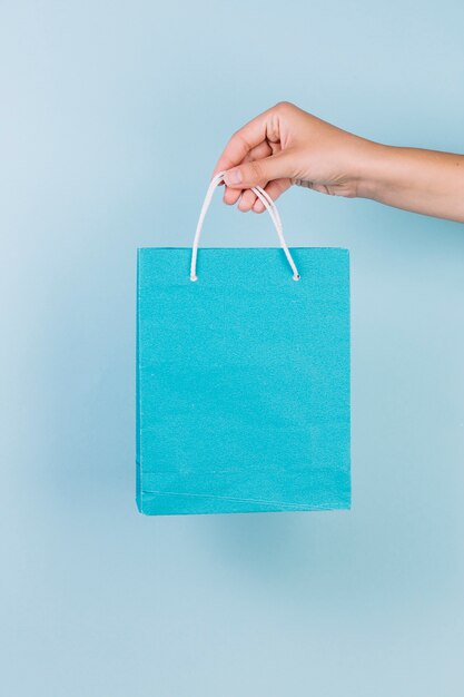 Osoba ręka trzyma błękitnego papieru torba na zakupy
