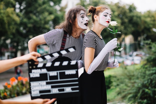 Bezpłatne zdjęcie osoba ręka trzyma clapperboard przed mim parą