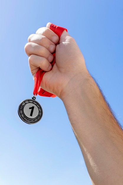 Bezpłatne zdjęcie osoba trzymająca jego medal numer jeden