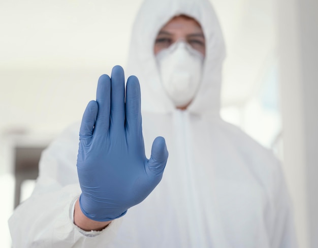 Osoba w masce medycznej, ubrana w sprzęt ochronny przed zagrożeniem biologicznym