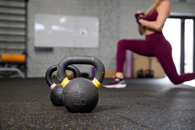 Osoba w sportowej siłowni używająca kettlebells