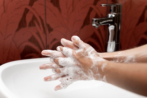 Osoba z boku myjąca ręce mydłem w postaci stałej