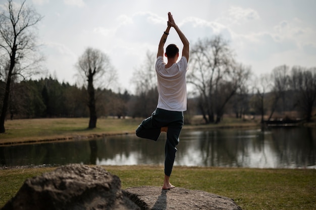 Bezpłatne zdjęcie osoby ćwiczące jogę na zewnątrz