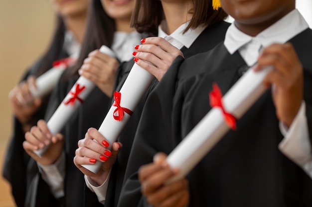 Bezpłatne zdjęcie osoby kończące studia z bliska dyplomy